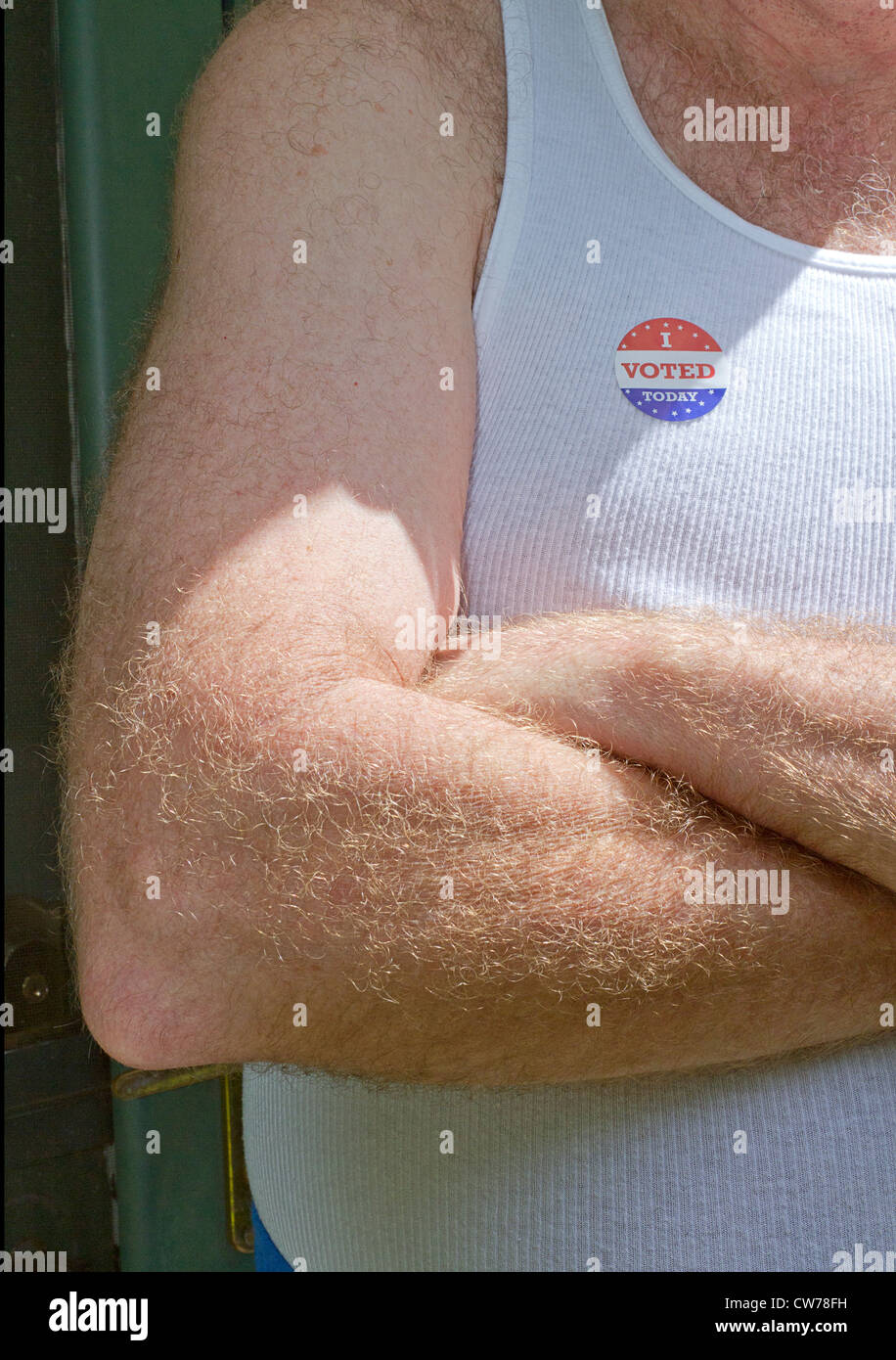 In prossimità di una mezza età uomo bianco con le braccia incrociate e un 'ho votato oggi' stick sulla sua maglietta bianca Foto Stock