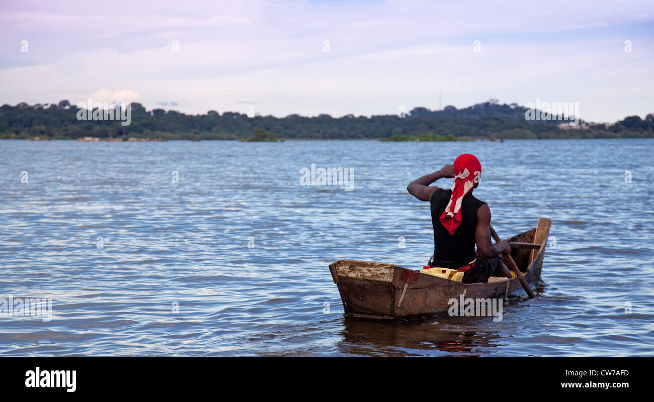 Muscoloso giovane pescatore in sella alla sua barca sul Lago Kivu, Uganda Entebbe Foto Stock