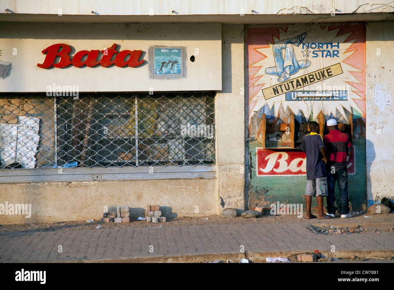 Scena di strada nella capitale con piccoli negozi vicino al mercato principale e due uomini utilizzando un telefono pubblico, Burundi Bujumbura Mairie, Bujumbura Foto Stock