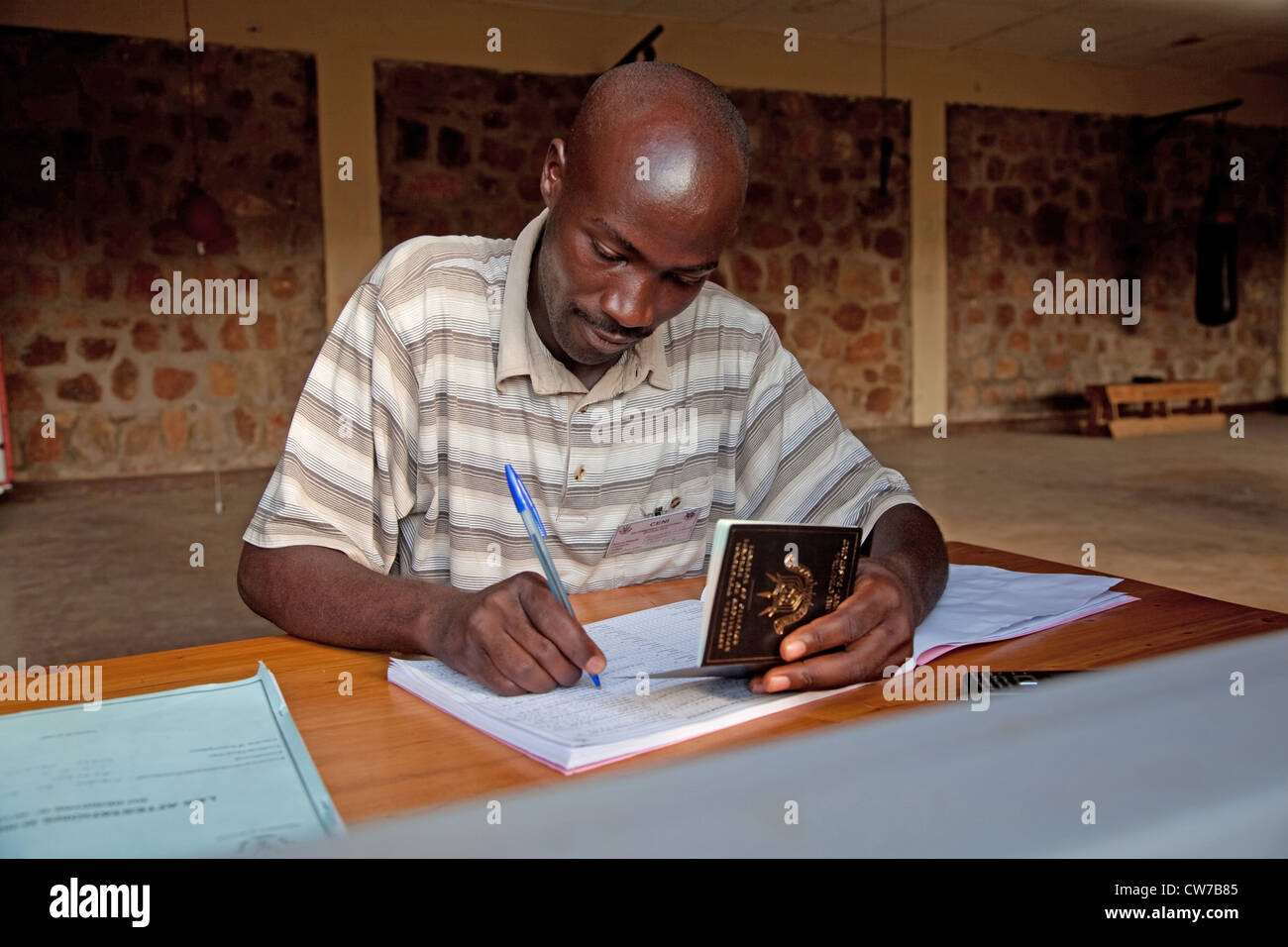 Funzionario amministrativo è la registrazione di un elettore ammissibili per le elezioni nazionali 2010 consultando la persona del passaporto, Burundi Bujumbura Mairie, Bujumbura Foto Stock