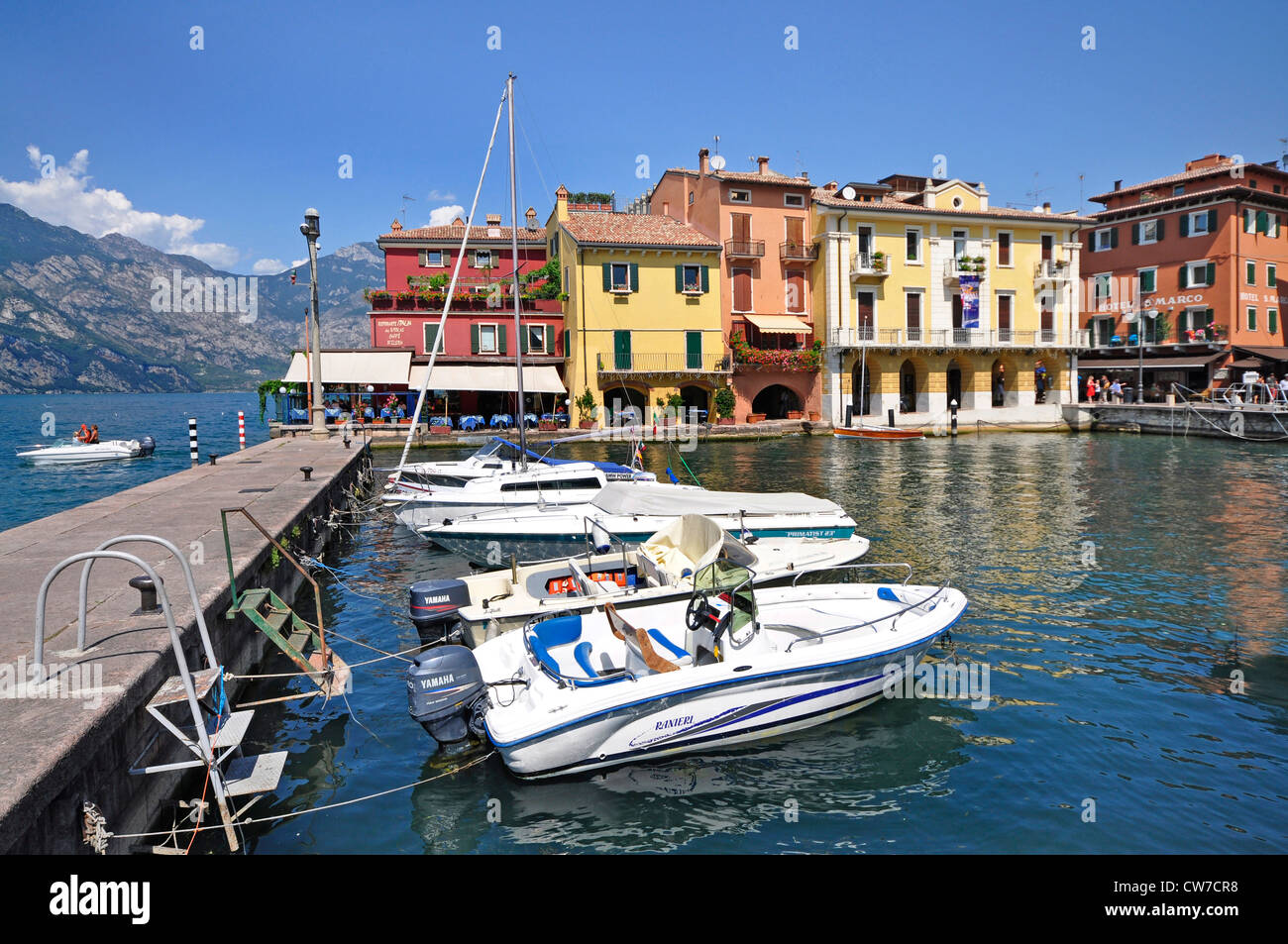 Lungomare del porto con barche a ribalta- e la gamma della montagna in background, Italia, Lago di Garda Malcesine Foto Stock