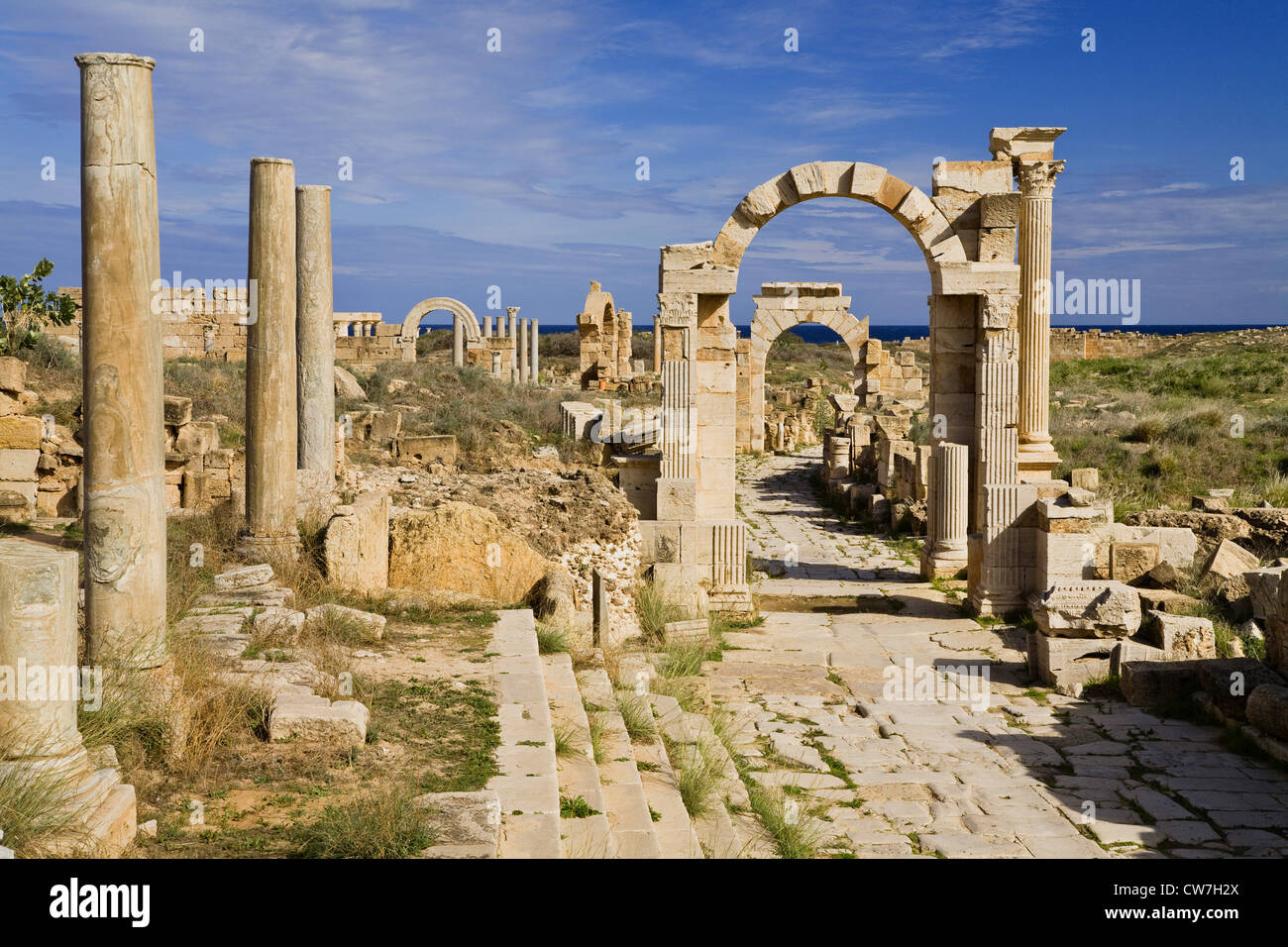 Via Trionfale con l Arco di Traiano a prua- e l'arco di Tiberio in background, Libia, Leptis Magna Foto Stock