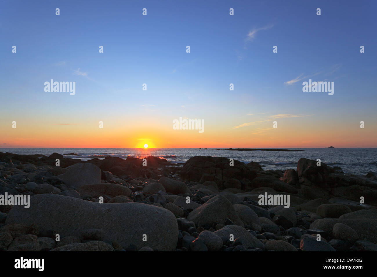 Guardando il tramonto sul mare, prese a Sennen Cove, Cornovaglia con la Brisons all'orizzonte. Foto Stock