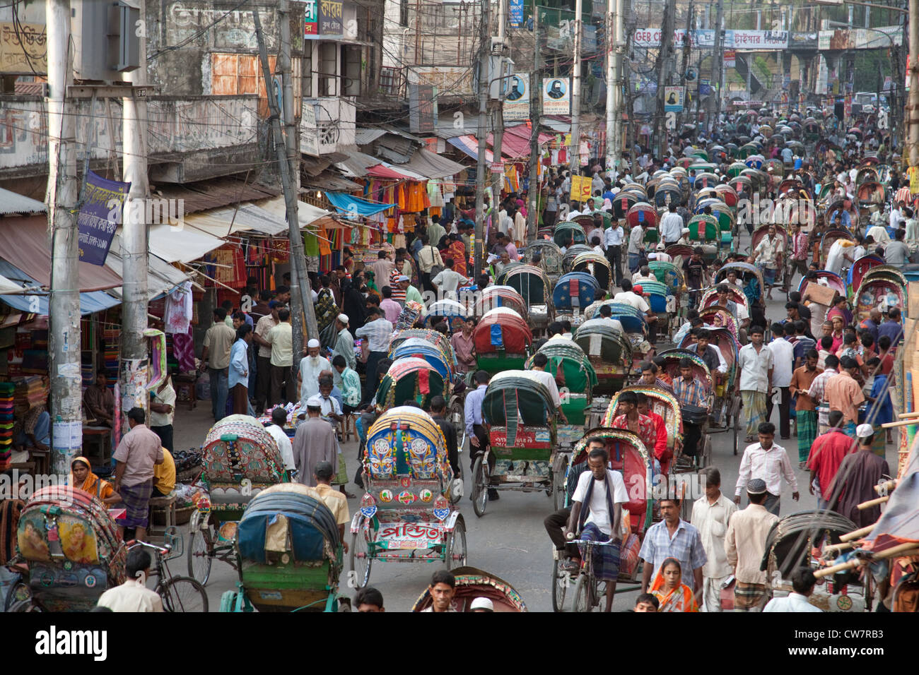Una strada affollata di risciò e persone nella vecchia Dacca in Bangladesh Foto Stock