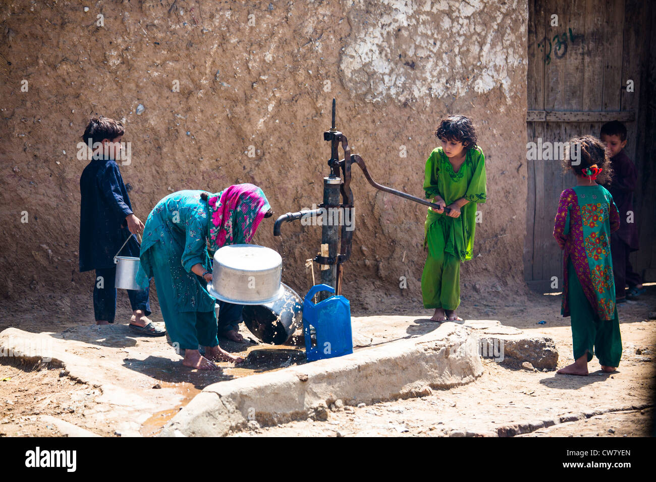 Bambini pakistani operando una pompa ad acqua a Rawalpindi, Pakistan Foto Stock