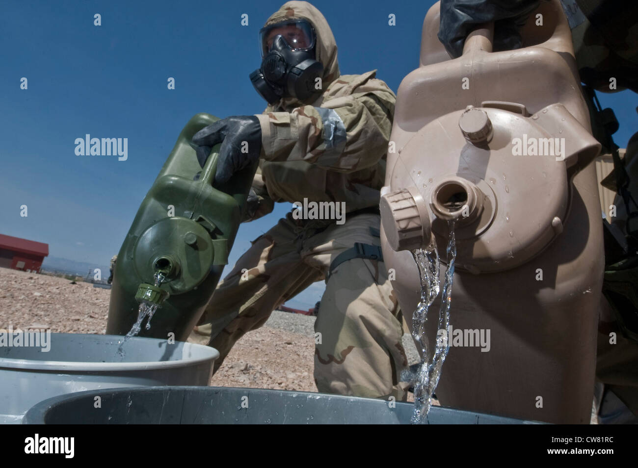 US Air Force Airborne esplosivo ordnance Disposal Airmen assegnato al 820esimo Squadron Red Horse versare liquidi di decontaminazione in un secchio durante un esercizio di formazione 14 agosto 2012, alla base dell'aeronautica di Nellis, Nev. i liquidi vengono utilizzati per decontaminare gli Airmen che entrano in contatto con sostanze chimiche o sconosciute. Foto Stock