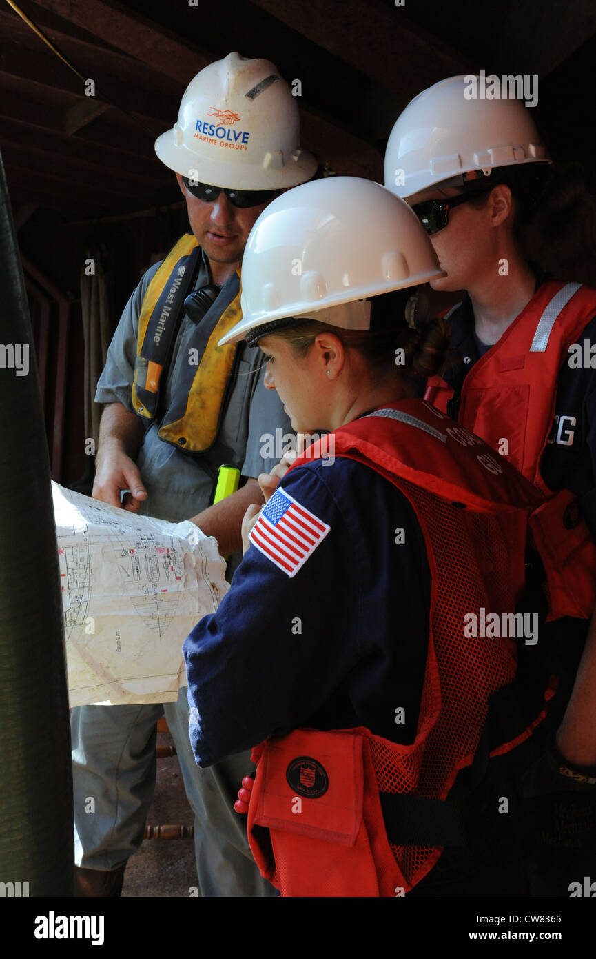 Cody Kurtz con il Resolve Marine Group parla con il Lt. Kristen Preble del settore della Guardia Costiera San Juan e il Lt. Meghan Sinclair con il team di risposta della Guardia Costiera Salvage Engineering sulla risposta a bordo del freighter Jireh di 202 piedi a terra sull'Isola di Mona, 15 agosto 2012. Il comando unificato di messa a terra della Jireh sta lavorando per salvare e rimuovere in modo sicuro l'imbarcazione che si è arenata il 21 giugno 2012. Foto Stock