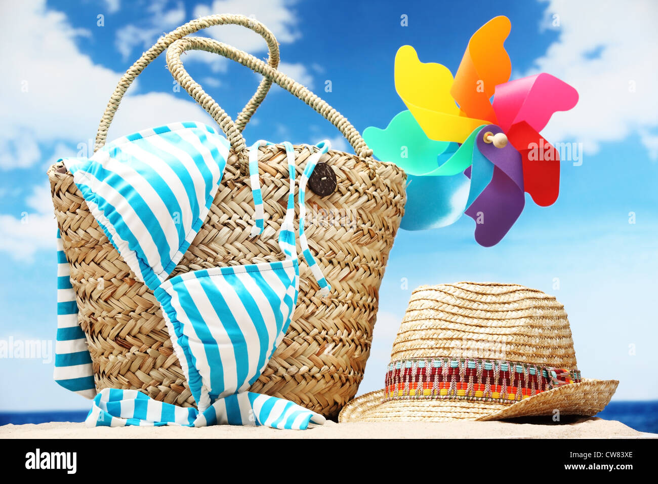 Primo piano della estate borsa da spiaggia con gli articoli sulla spiaggia sabbiosa Foto Stock