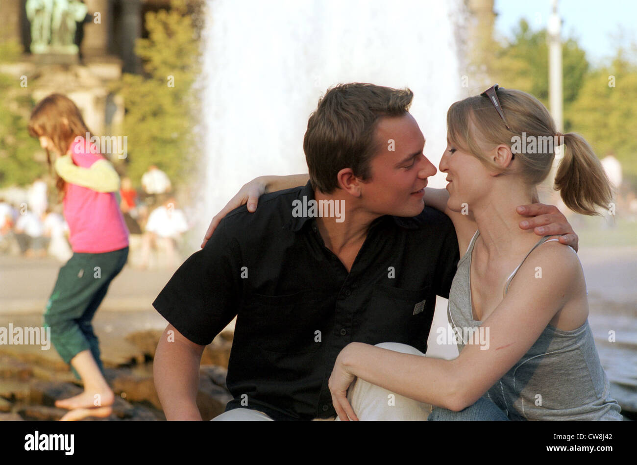 Berlino, giovane baci davanti a fontana Foto Stock