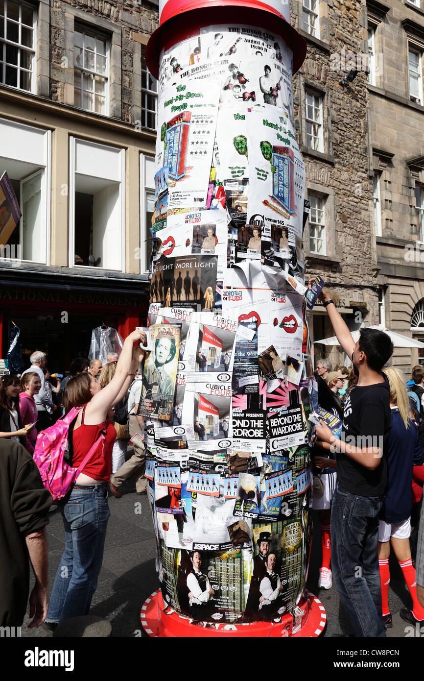 Persone che mettono su poster Edinburgh Festival Fringe su una torre pubblicitaria, Royal Mile, Scozia, Regno Unito Foto Stock