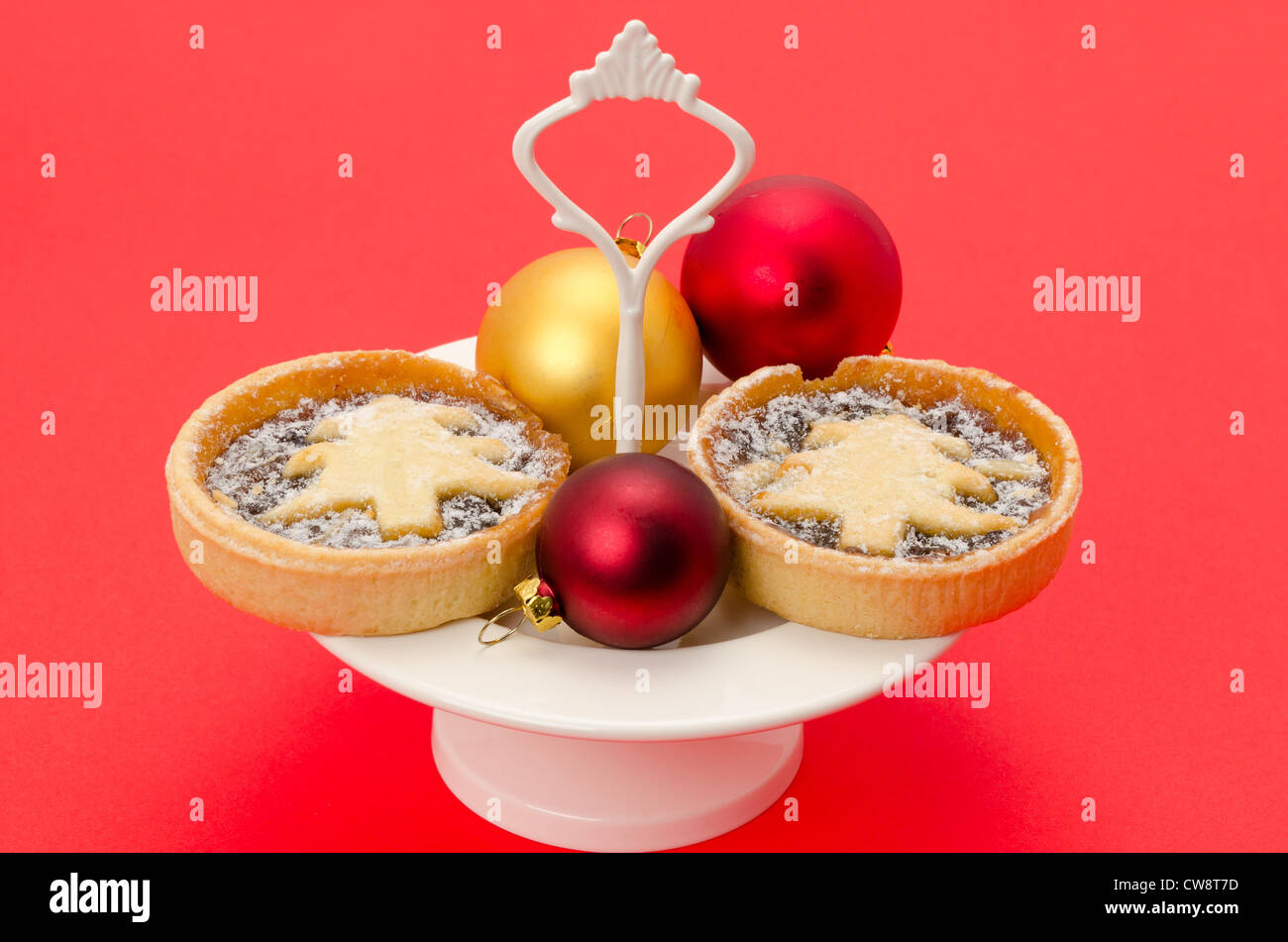 Festa di Natale o pasticci di carne macinata preparata di fresco e posti su una piastra di torta - studio shot con uno sfondo rosso Foto Stock