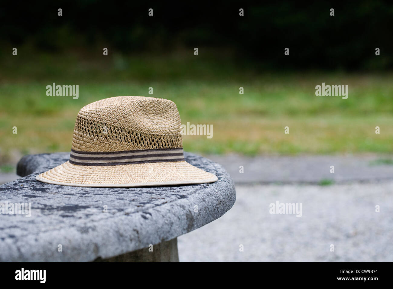 Uomo di cappello di paglia su un vecchio banco di pietra. Foto Stock