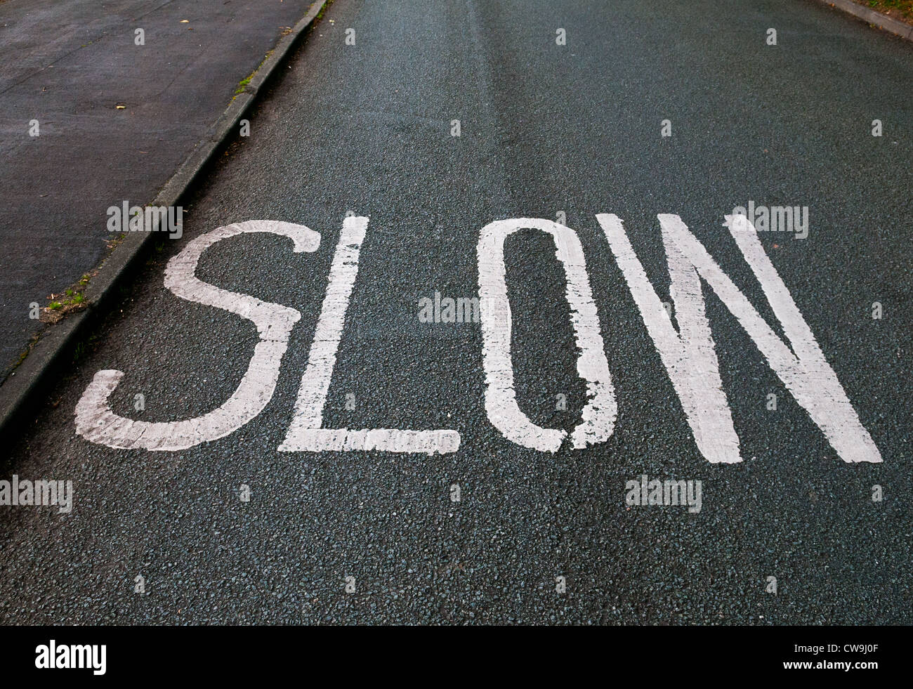 'Slow' segno dipinto su una strada a Shifnal, Shropshire, Inghilterra. Foto Stock