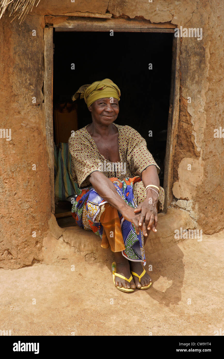 Donna seduta nella porta della sua con tetto di paglia di capanna di fango, Gambaga, Ghana Foto Stock
