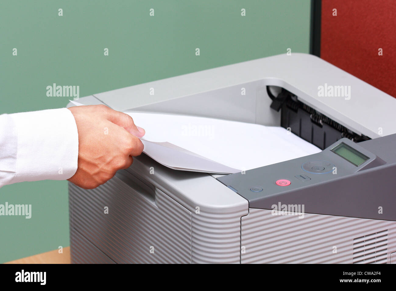 Imprenditore lavora con stampante in ufficio Foto Stock