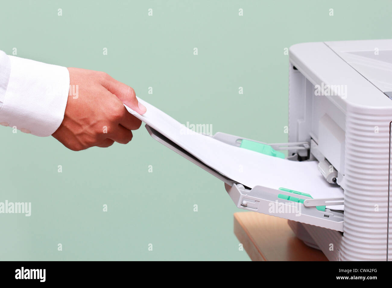 Imprenditore lavora con stampante in ufficio Foto Stock