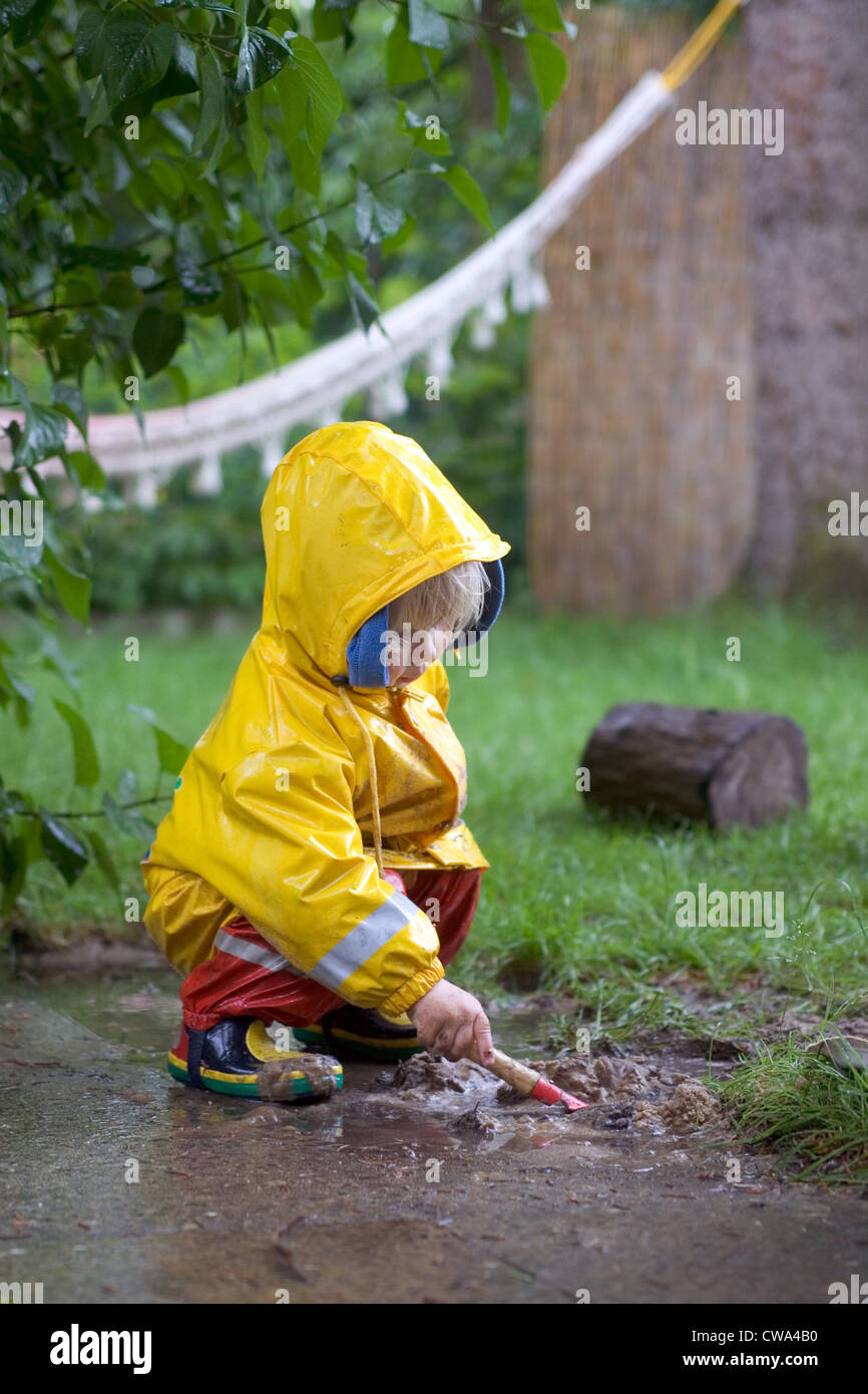 Berlino, un piccolo bambino che gioca al di fuori nel fango Foto Stock