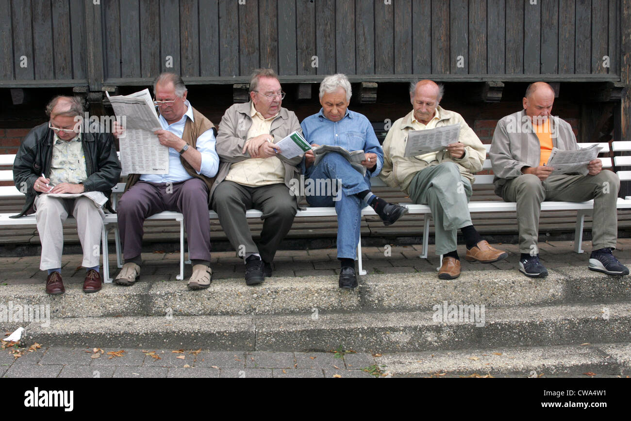 A Dresda, uomini anziani siedono su Parkbaenken e leggere quotidiani Foto Stock