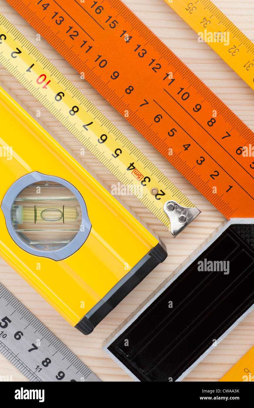 Un assortimento di strumenti di misurazione, disposto su una superficie di legno, come un sfondo astratto Foto Stock