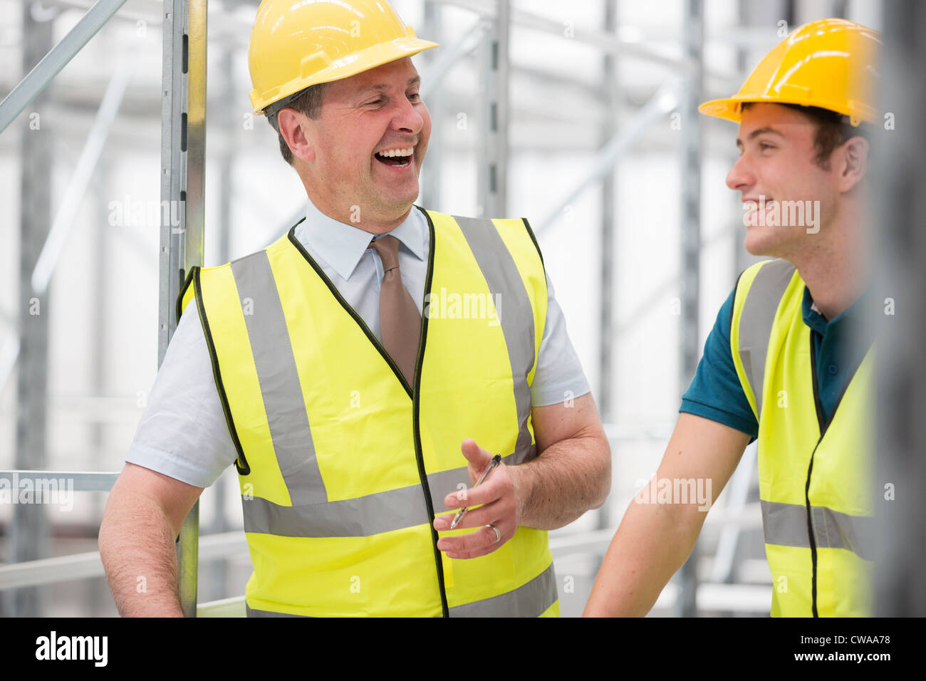 Due uomini ridere in magazzino Foto Stock