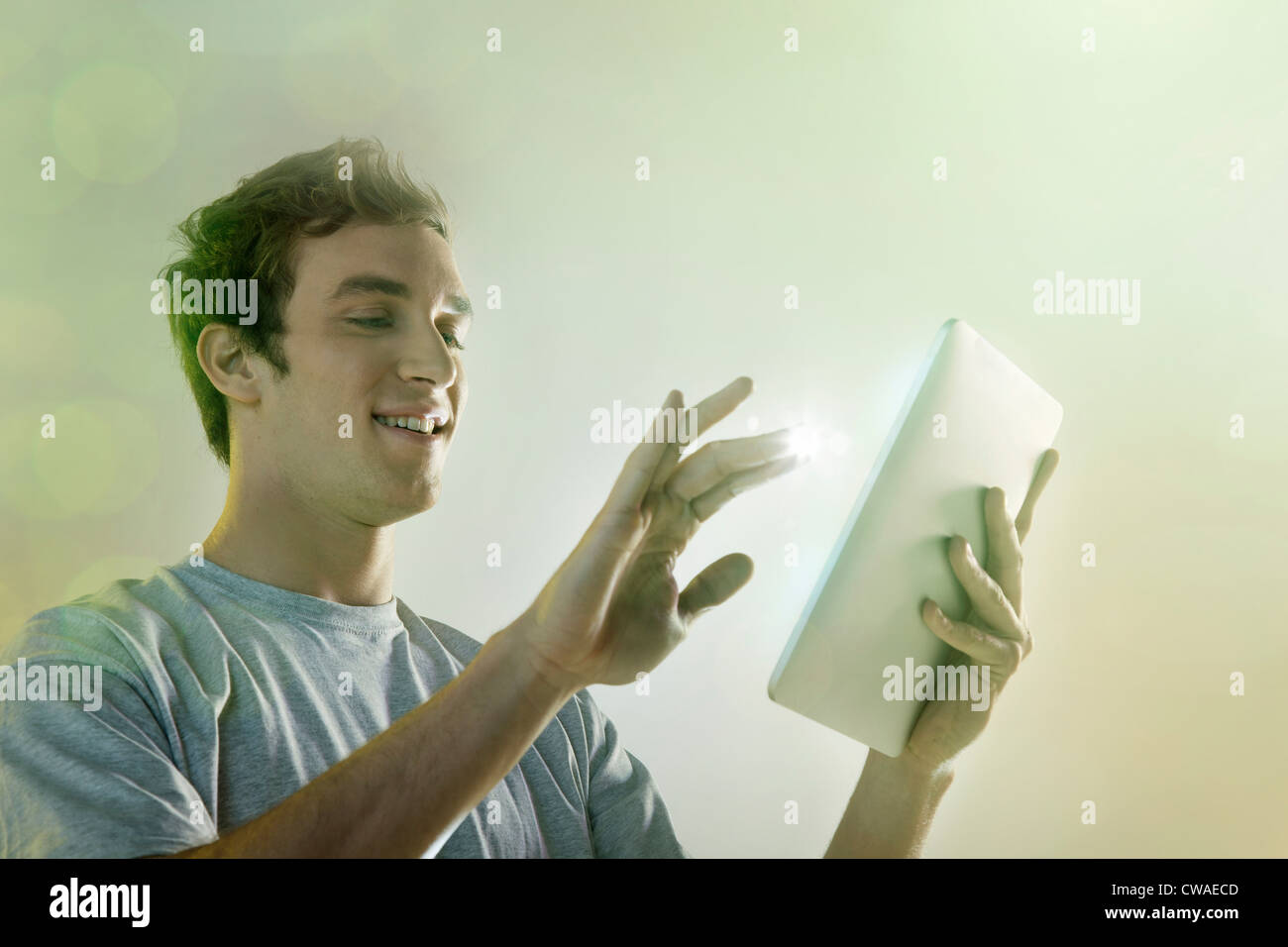 Giovane uomo con tavoletta digitale con luci Foto Stock