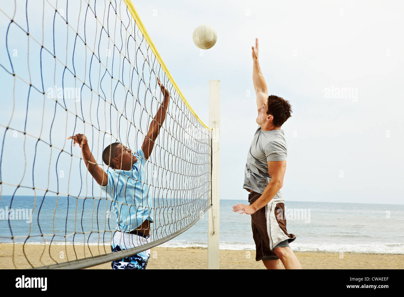 Due giovani uomini a giocare a beach volley Foto Stock