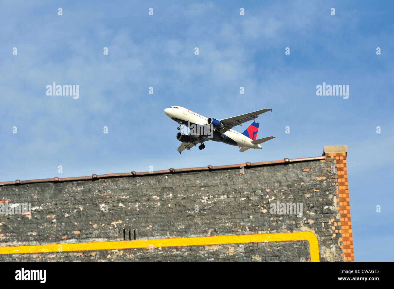 Delta Air Lines jet vicino agli edifici circostanti del Chicago lato sud-ovest quartiere Midway Airport. Chicago, Illinois, Stati Uniti d'America. Foto Stock