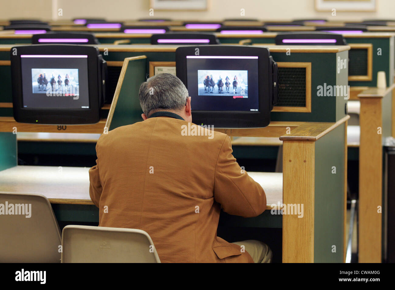 New York uomo in una sala scommesse a Belmont Park Racetrack Foto Stock