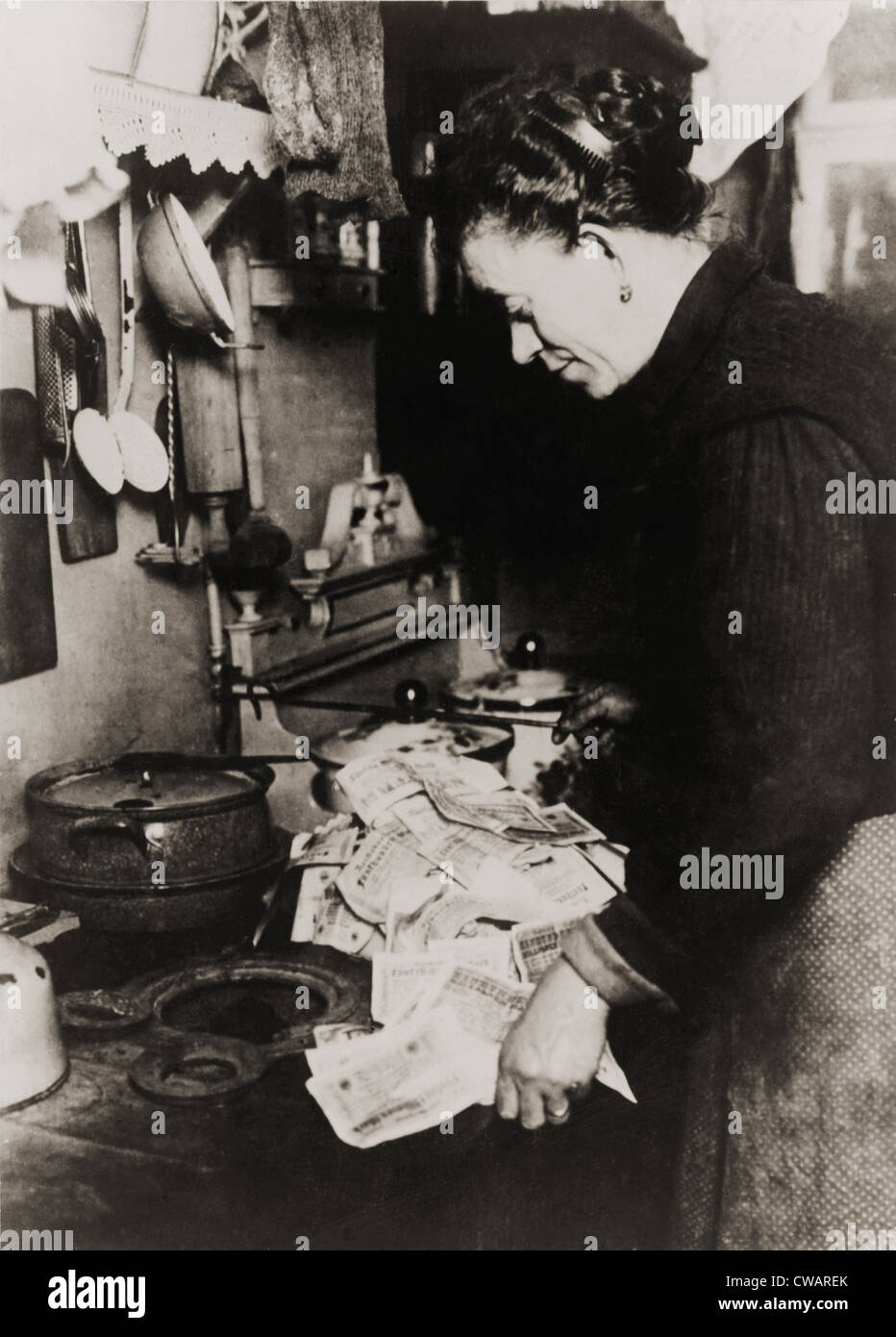 Tedesco donne bruciando denaro per il suo combustibile stufa durante il post guerra mondiale I iper-inflazione nel 1923. Al momento, un americano Foto Stock