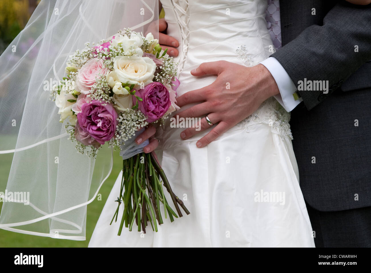 Sposi abbracciando con sposa bouquet Foto Stock