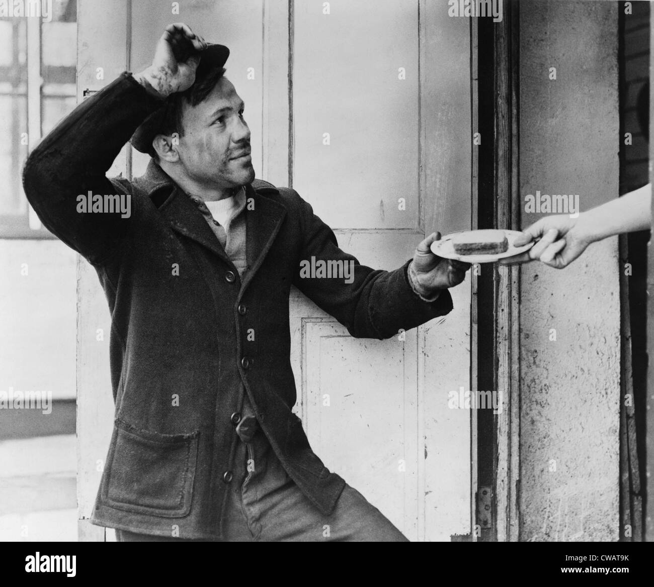 Un Hobo, Lou ambre, suggerimenti il suo cappello come egli accetta un sandwich da una donna di mano durante la Grande Depressione. Disoccupati gli uomini erano Foto Stock
