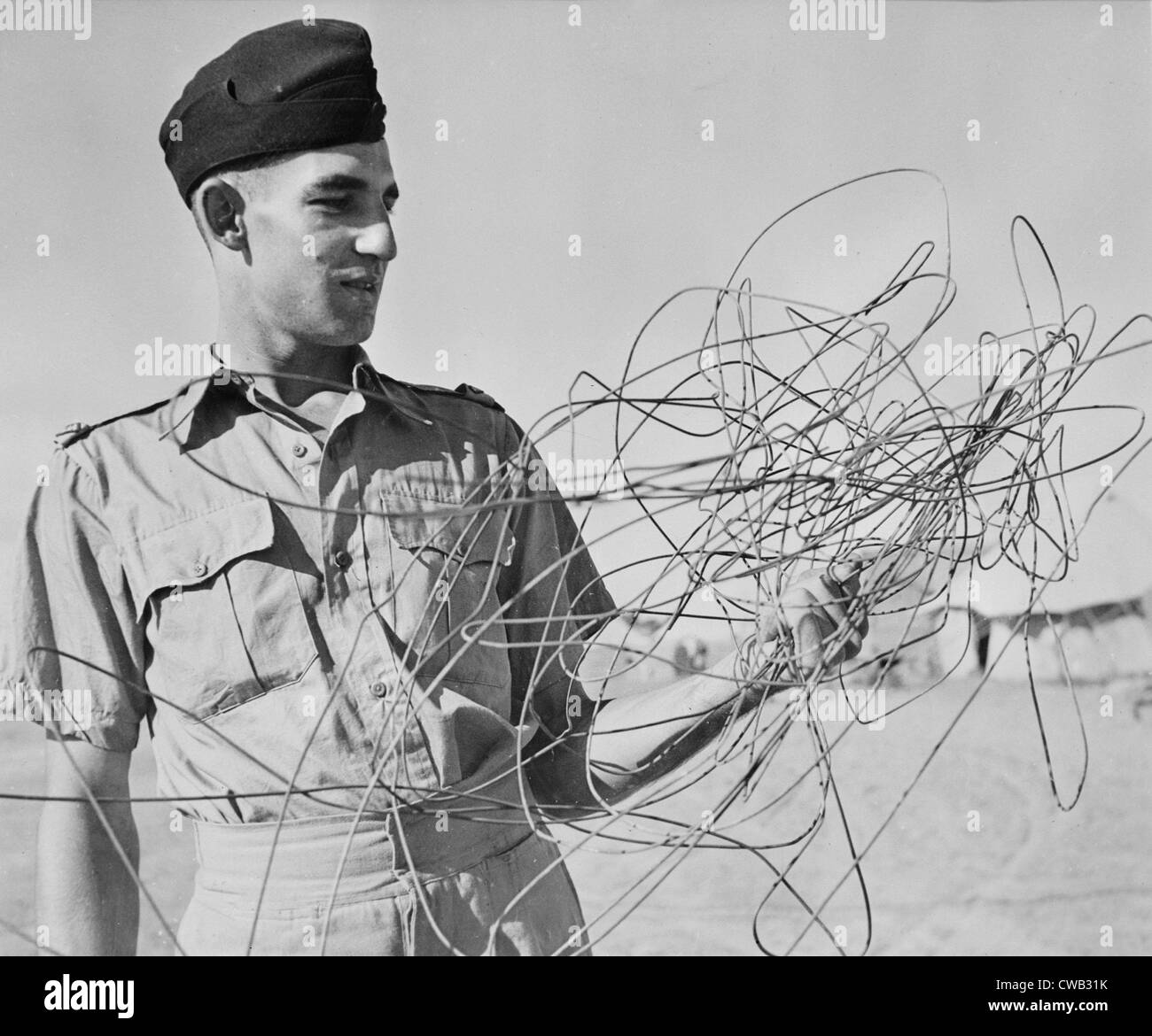 La II Guerra Mondiale, sergente C.M. Corazzata, di Sydney, Australia, leader di un Royal Air Force attack, esaminando il filo telefonico Foto Stock