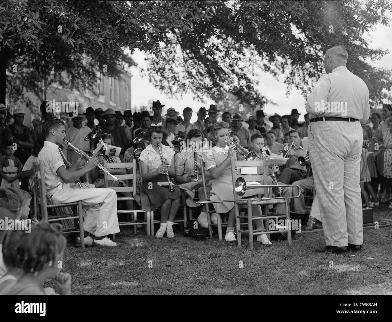 Una band leader e la sua band, didascalia originale: "La high school band aveva messo in pratica per settimane. Home guard passa attraverso Foto Stock