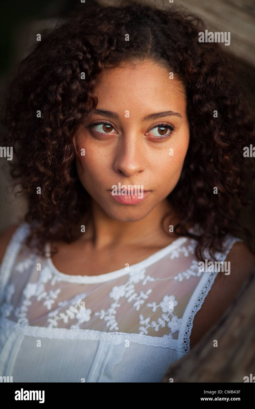 Una bella e giovane donna nera pone da driftwood. Foto Stock