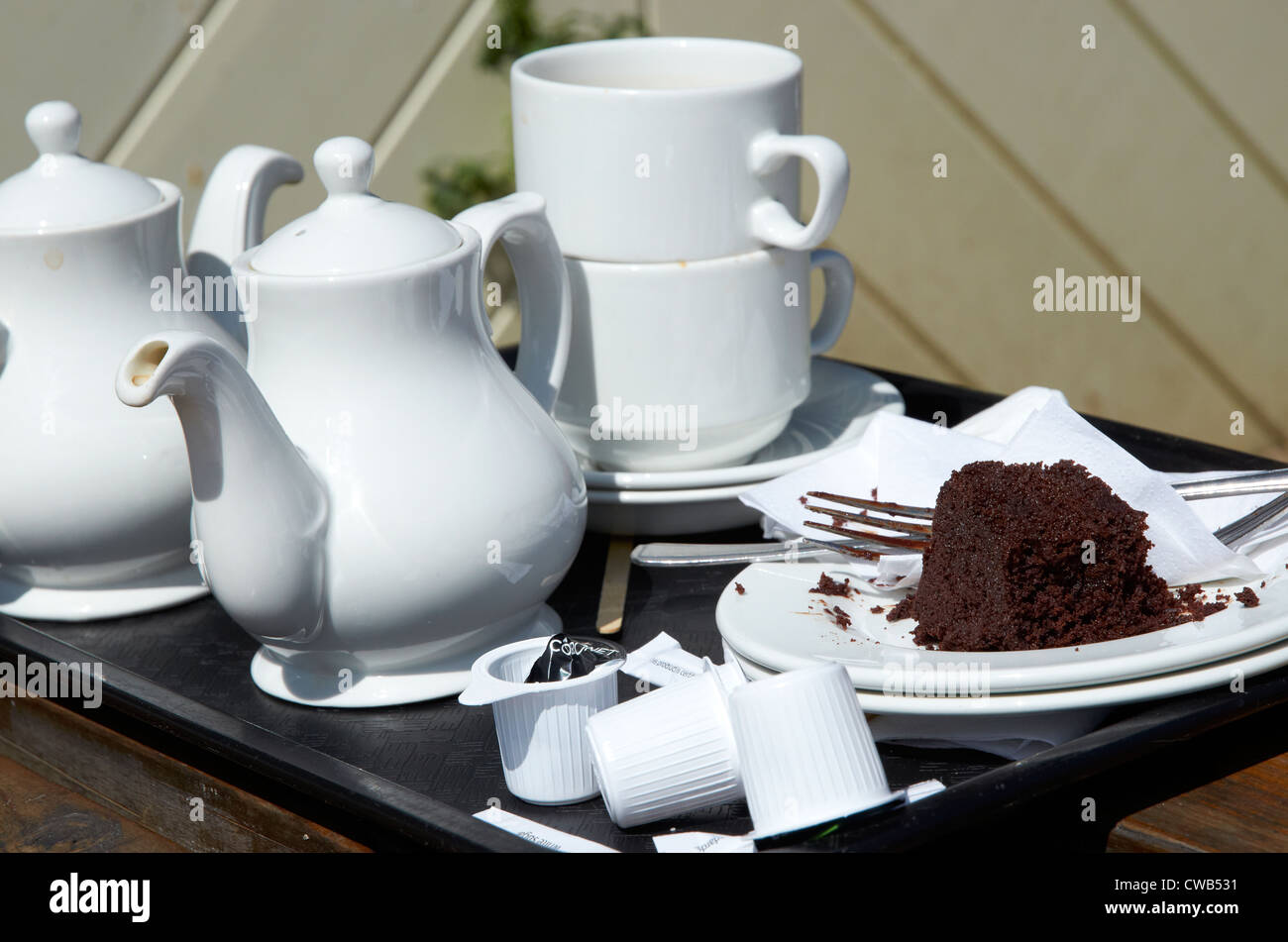 I detriti di un tè del pomeriggio con uneaten torta al cioccolato. Foto Stock