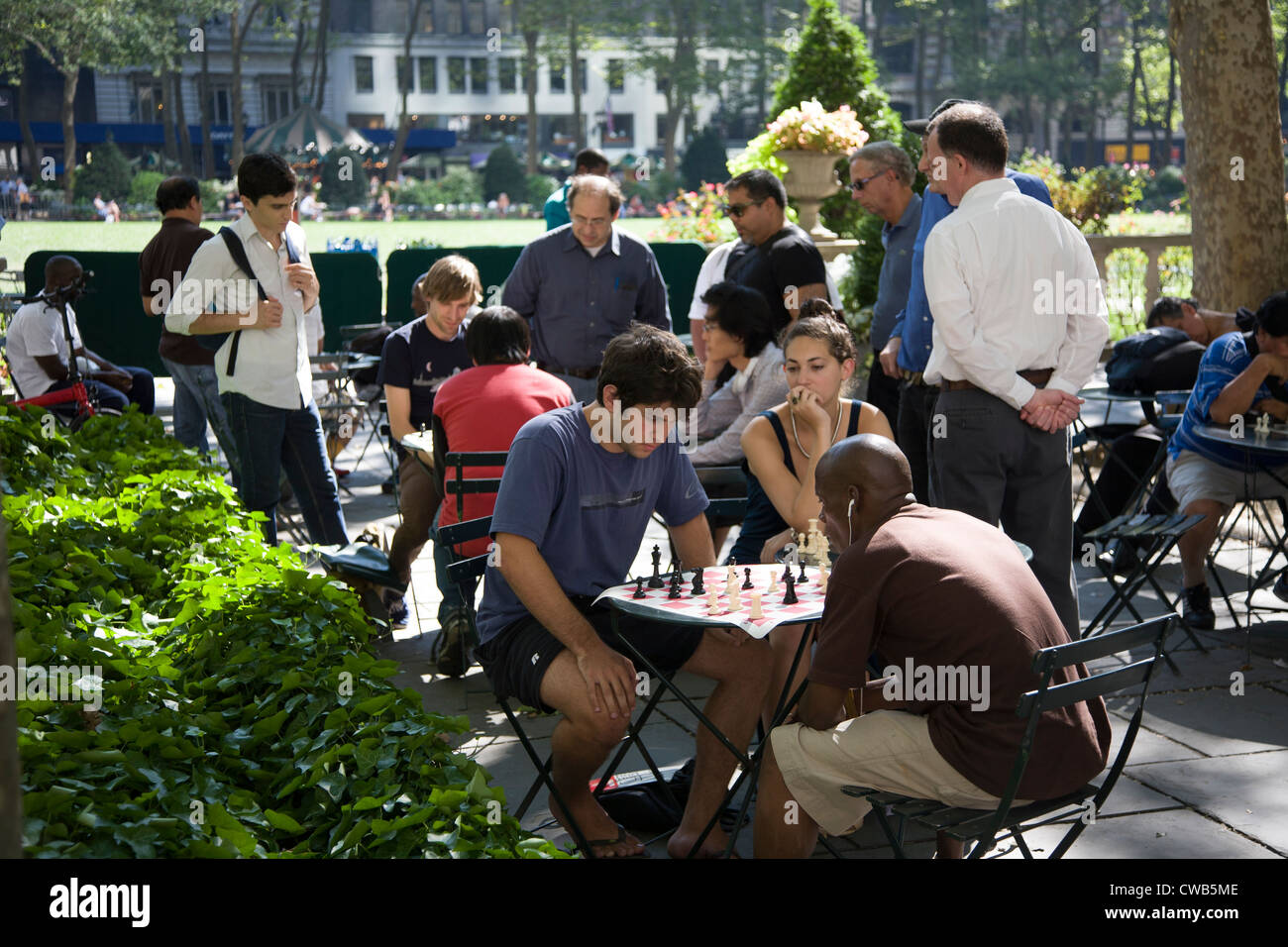 Persone giocare a scacchi in Bryant Park di New York City dietro la NY Public Library lungo 42nd St. Foto Stock