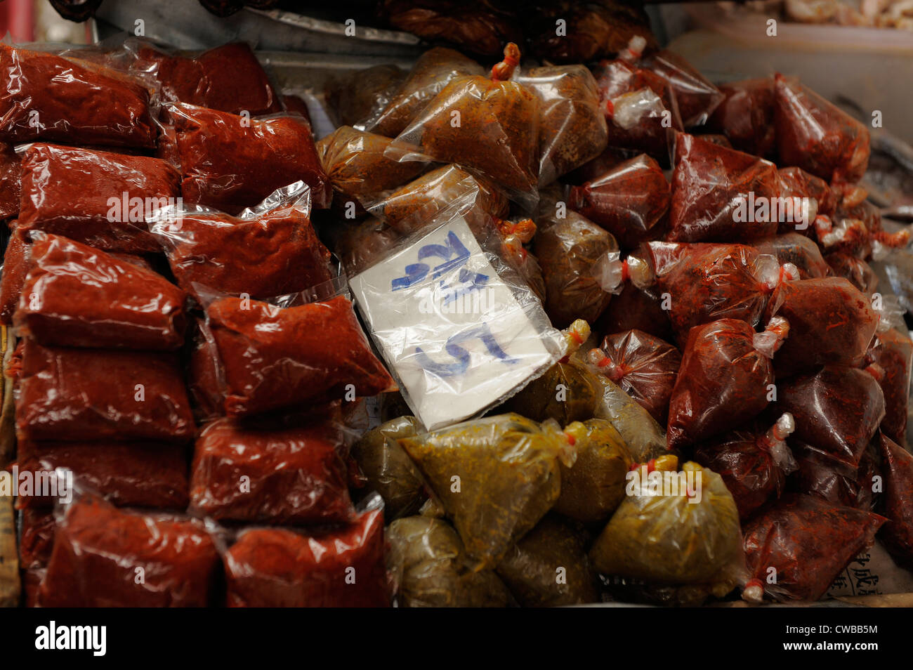 Una montagna di rosso e verde pasta di curry in sacchetti di plastica, klong toei mercato fresco , bangkok, Thailandia Foto Stock
