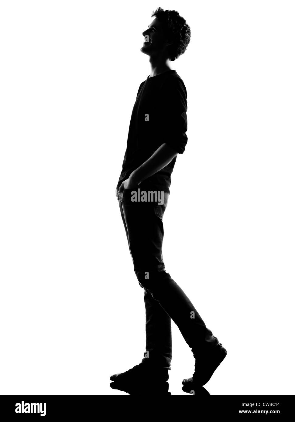 Giovane uomo che cammina felice ridere silhouette in studio isolato su sfondo bianco Foto Stock