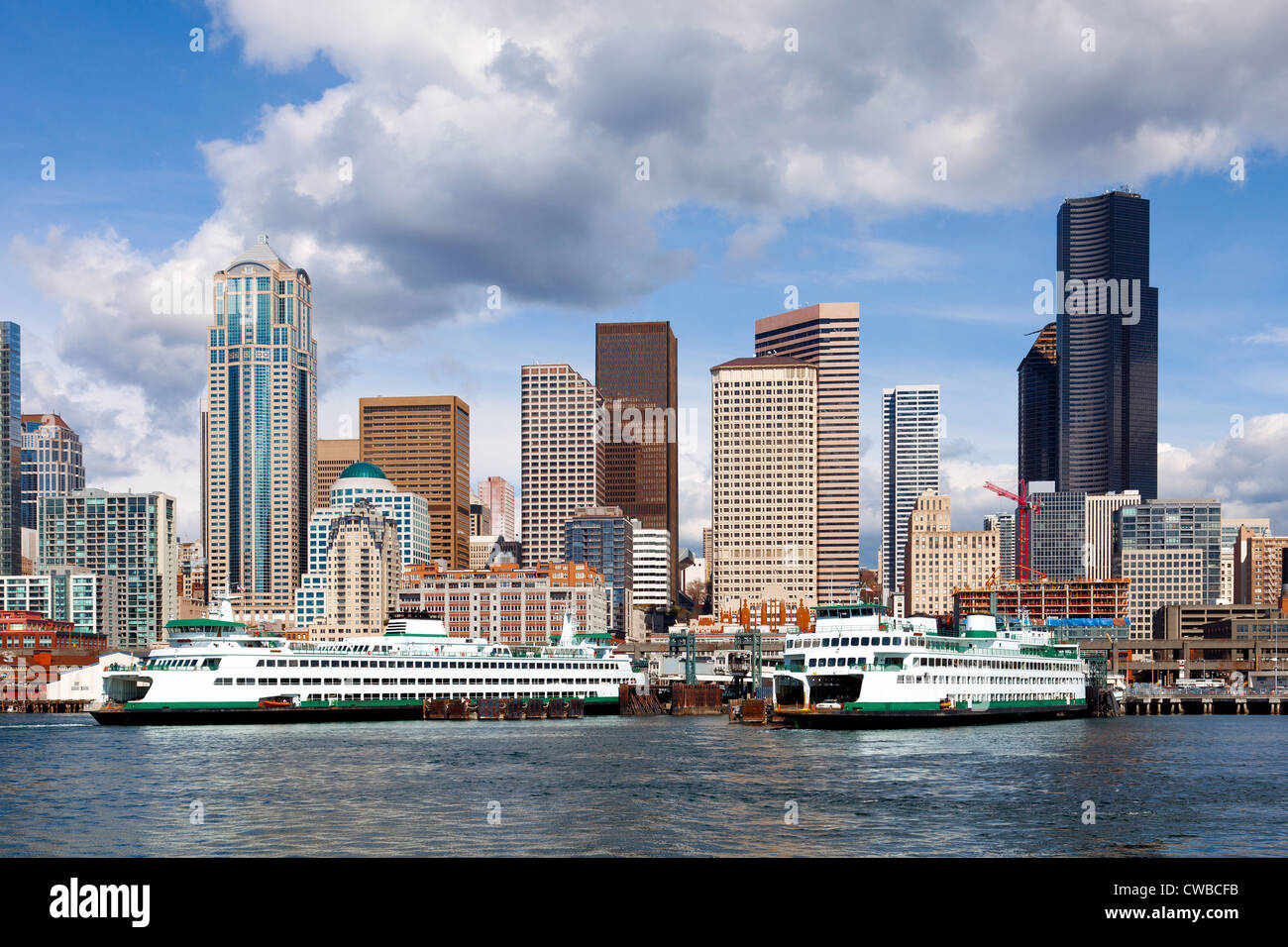 Seattle, Stati Uniti di Washington waterfront, traghetti, e sullo skyline su una luminosa giornata di sole con le nuvole Foto Stock
