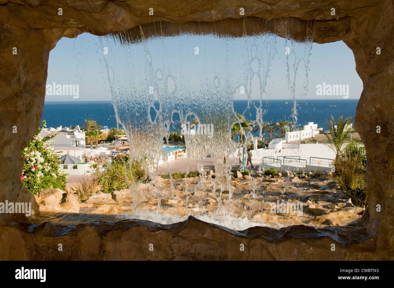 Il mare blu e un hotel territorio attraverso il telaio a cascata Foto Stock