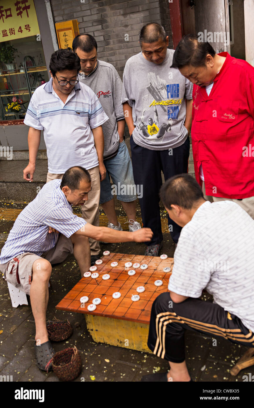 Gli uomini giocano Dou Shou Qi o giungla, un tradizionale gioco di bordo lungo un hutong di Pechino, Cina Foto Stock