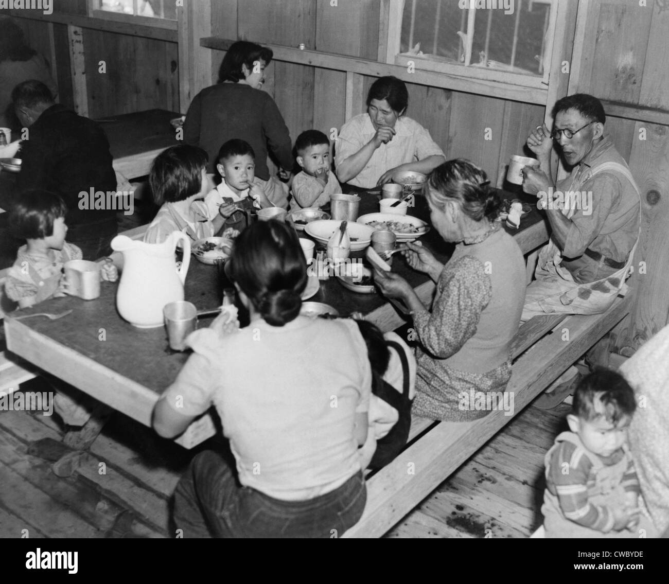 Più generazioni di giapponese americani al momento dei pasti nel Manzanar internamento Camp caserma area da pranzo. Foto Stock