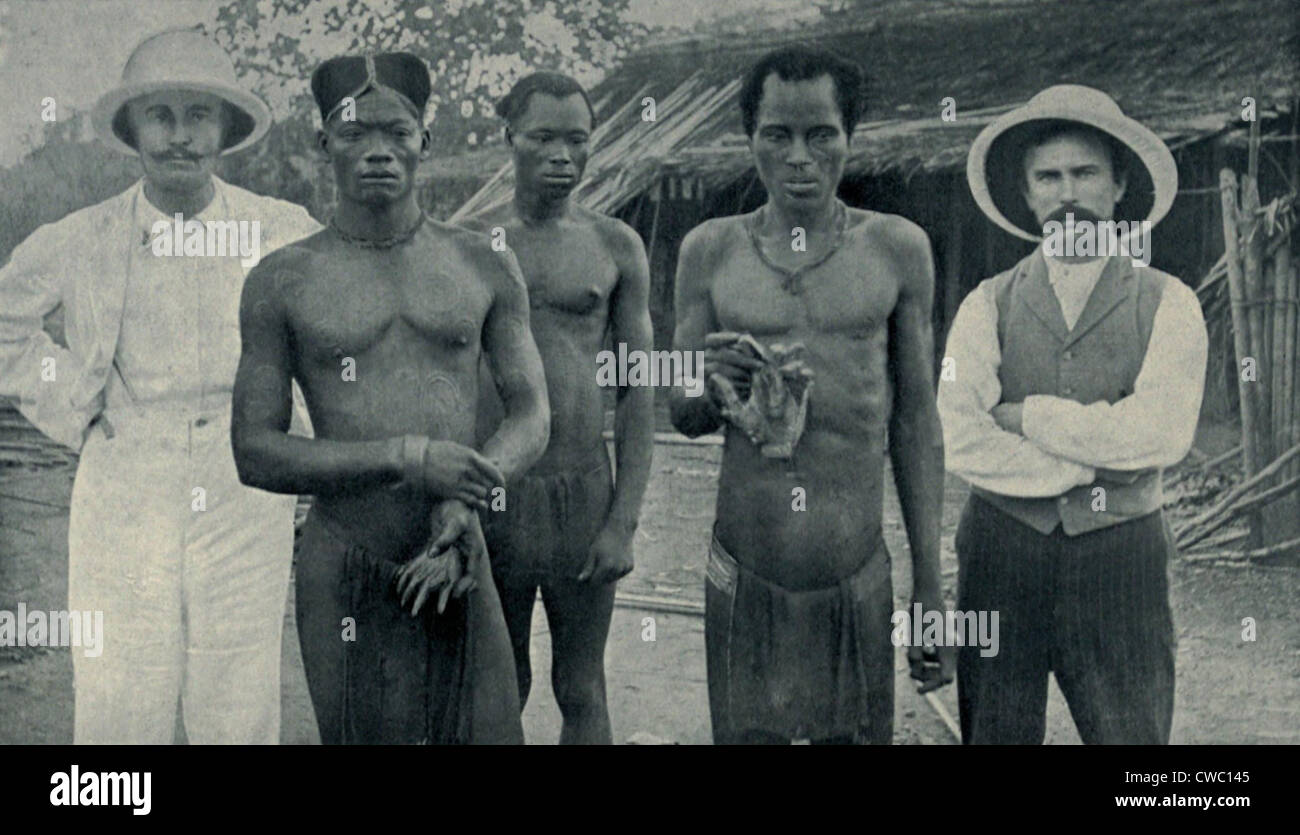 Le atrocità della gomma la schiavitù nel Congo Belga. I nativi di tenere le mani separate di due connazionali assassinati da gomma Foto Stock