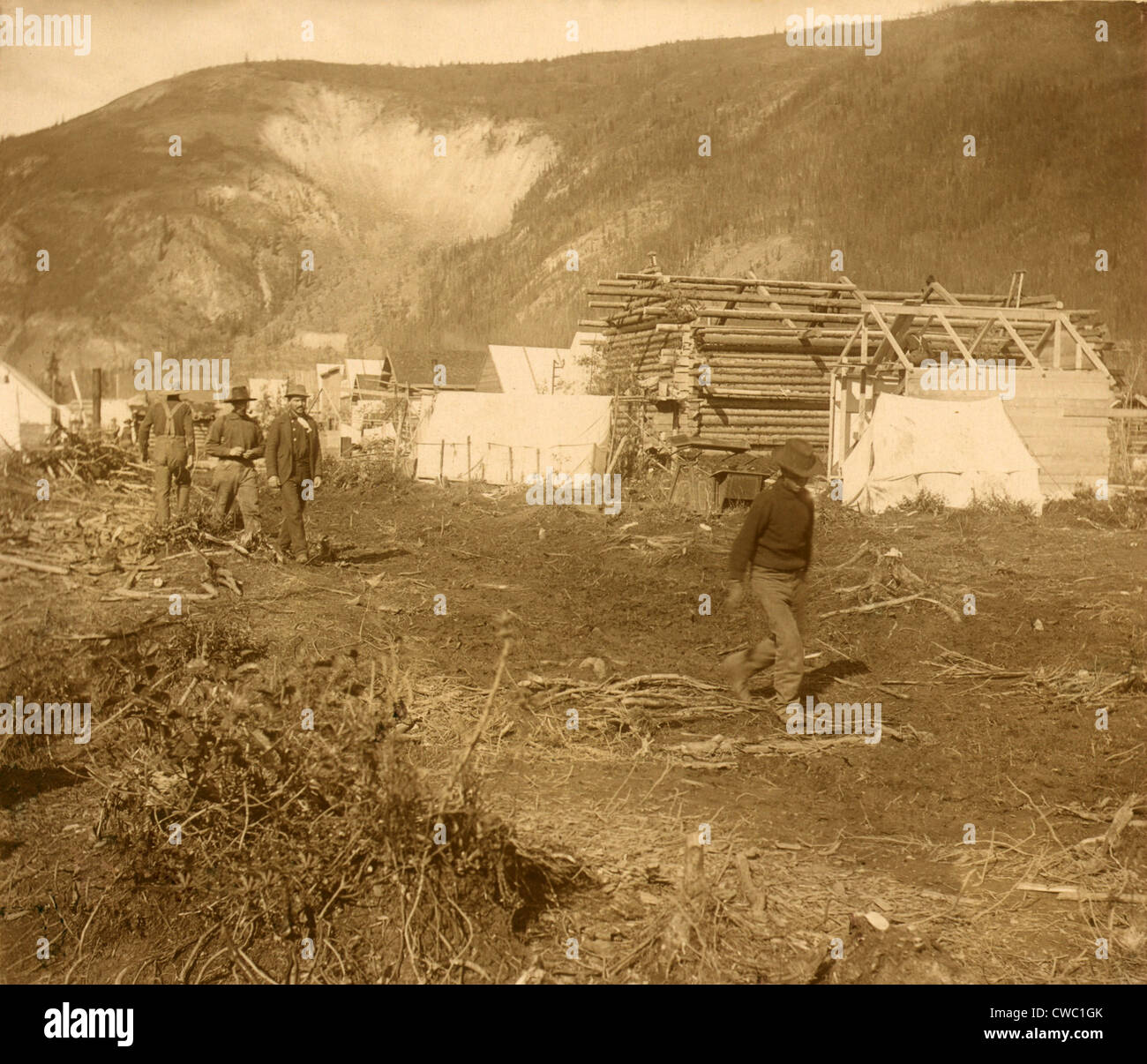 Gli uomini a camminare su Dawson City 'Riverside Drive,' nel 1897 durante la Yukon Gold Rush. La nuova strada è fiancheggiata con la città Foto Stock