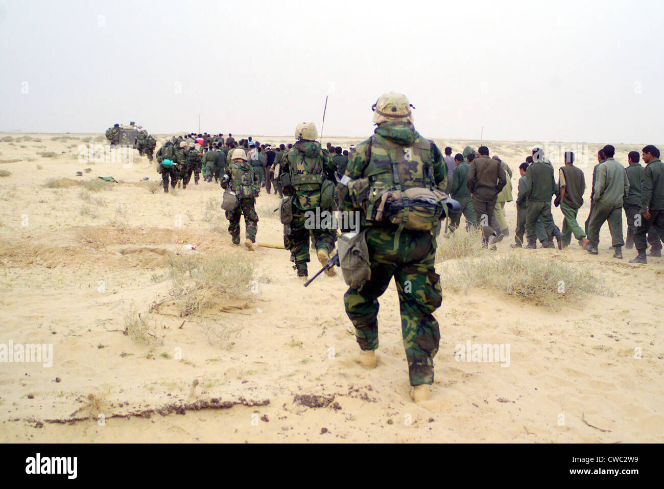 Stati Uniti Marines escort catturati al nemico di prigionieri di guerra ad una zona di tenuta nel deserto dell'Iraq il 21 marzo 2003 durante il funzionamento Foto Stock