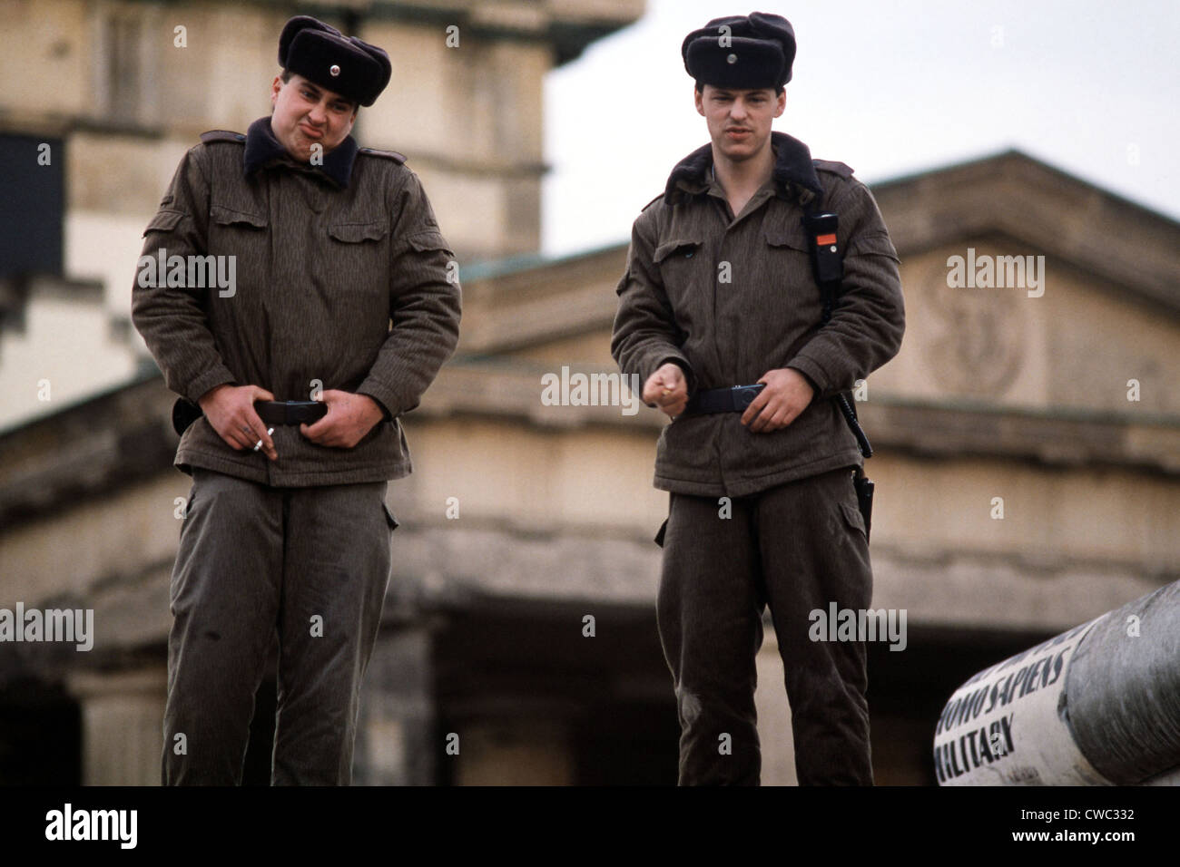 Oriente guardie tedesco a suo agio in cima al muro di Berlino alla Porta di Brandeburgo di Berlino est-ovest del confine sul 22 dicembre 1989. Foto Stock