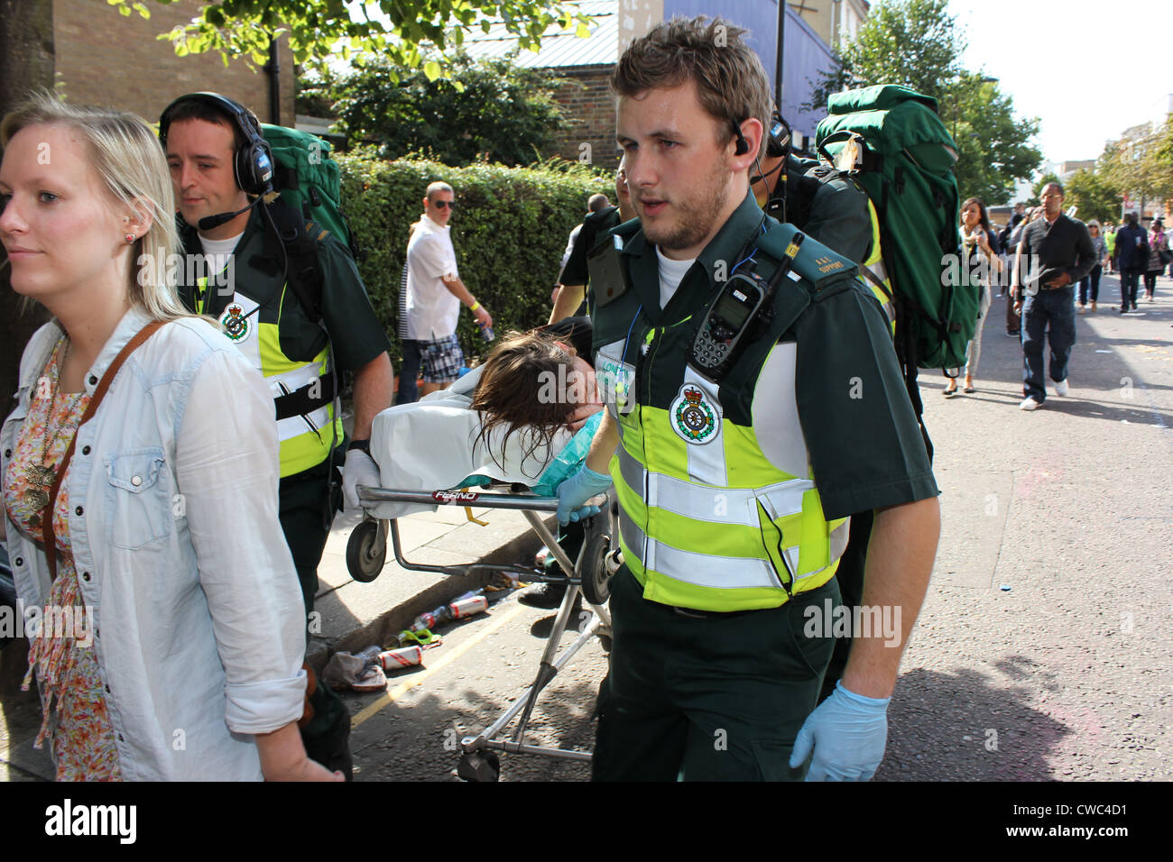 Londra un servizio di ambulanza che trasportano feriti donna sulla barella dalle strade durante il Notting Hill Festival Foto Stock