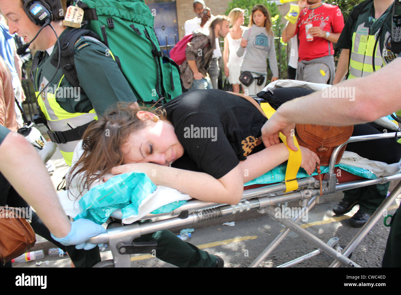 Londra un servizio di ambulanza che trasportano feriti donna sulla barella dalle strade durante il Notting Hill Festival Foto Stock