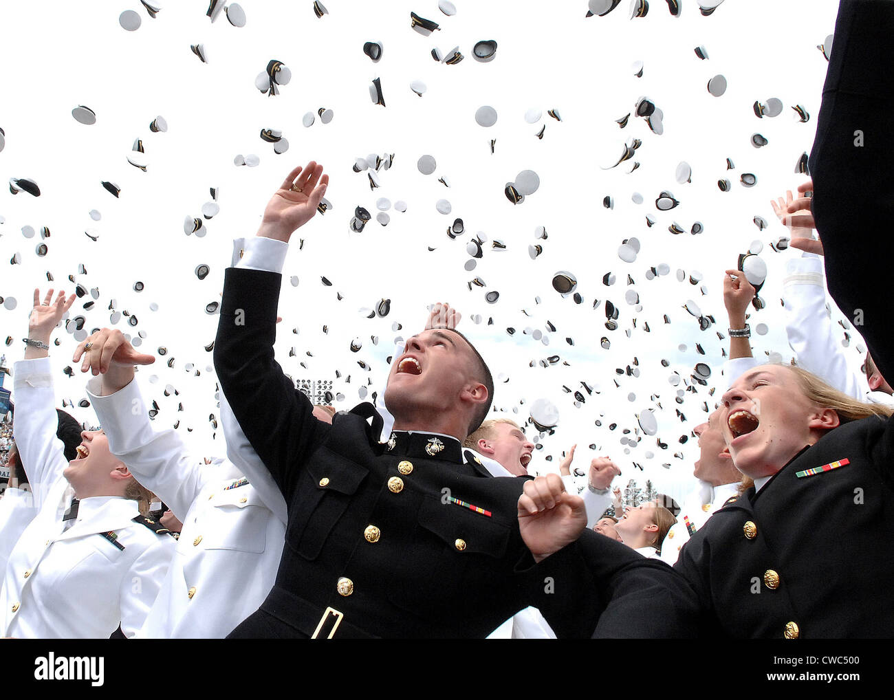 Recentemente commissionato Navy alfieri e Marine Corps 2a luogotenenti lanciano i loro cappelli in aria in loro 2006 graduazione e Foto Stock