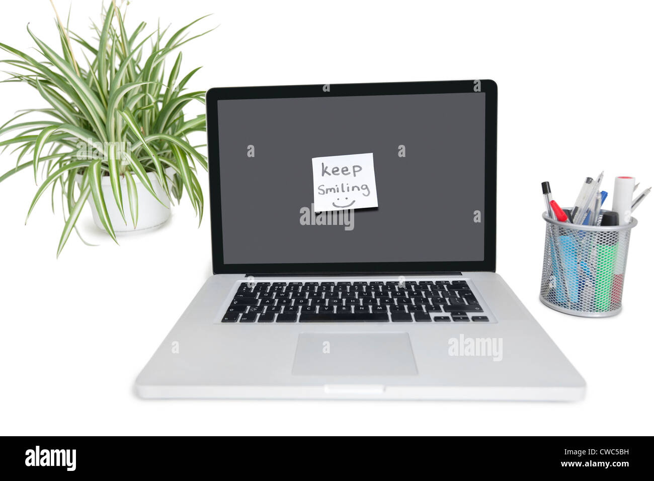 Smiley face nota adesiva su laptop con forniture di ufficio e impianto di pot Foto Stock